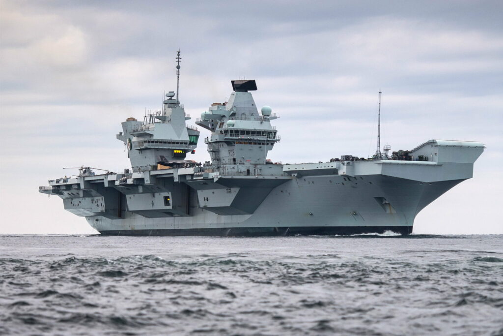 HMS Queen Elizabeth aircraft carrier sailing ocean under cloudy sky showing twin-island design Wallpaper