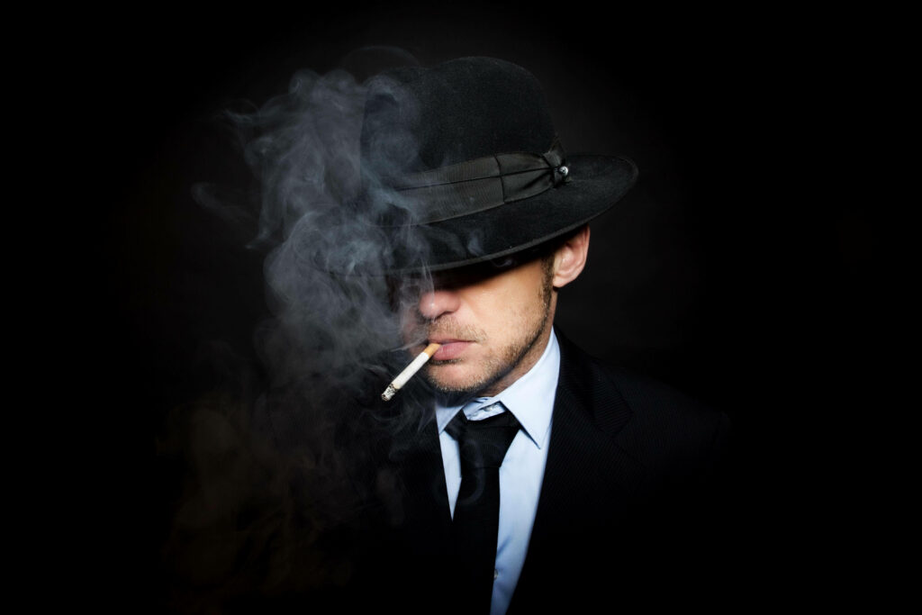 The Enigmatic Gentleman in the Shadows: A Mysterious Boy and his Smoke-Filled Ambiance. Wallpaper