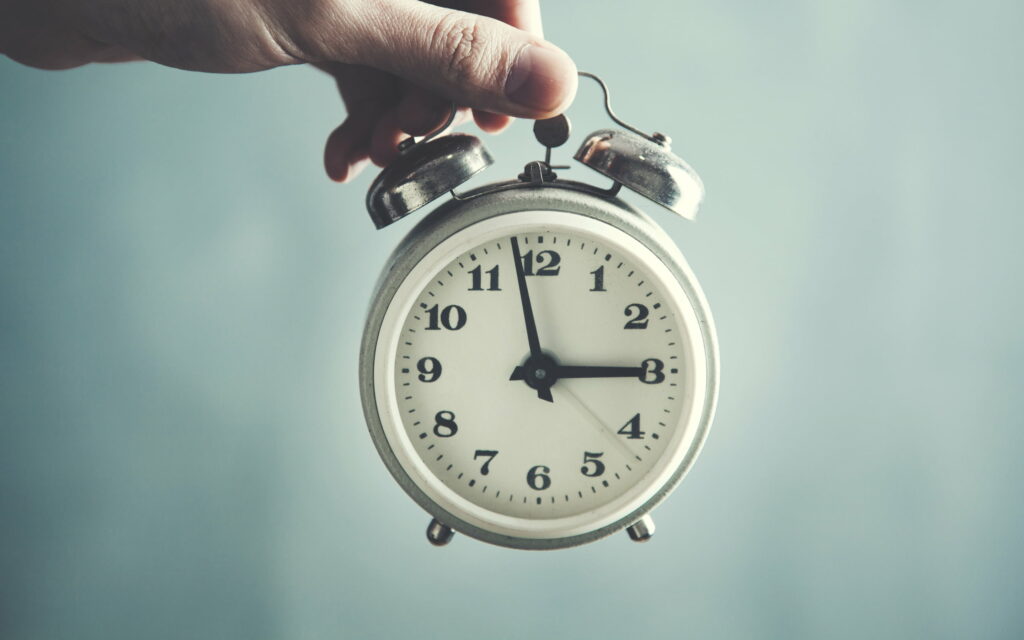 Seizing Every Moment: A Captivating Time Concept in the Hands of an Alarm Clock Wallpaper
