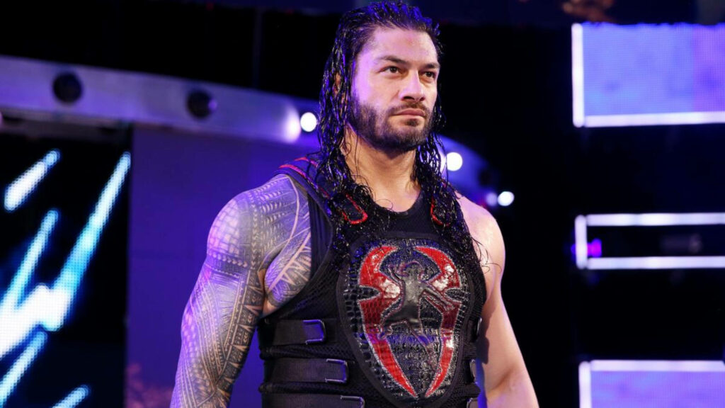 Muscular Wrestler Roman Reigns Stands Confidently in Sporty Attire at Event Wallpaper