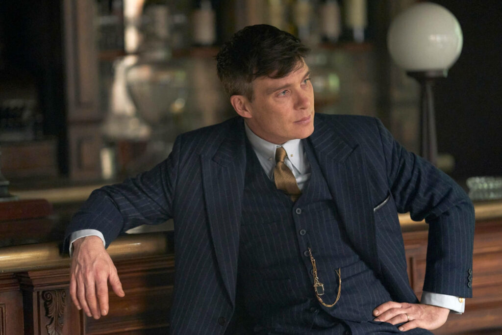 The Resolute Boss: Thomas Shelby, Leader of the Infamous Peaky Blinders, Commands the Pub Wallpaper