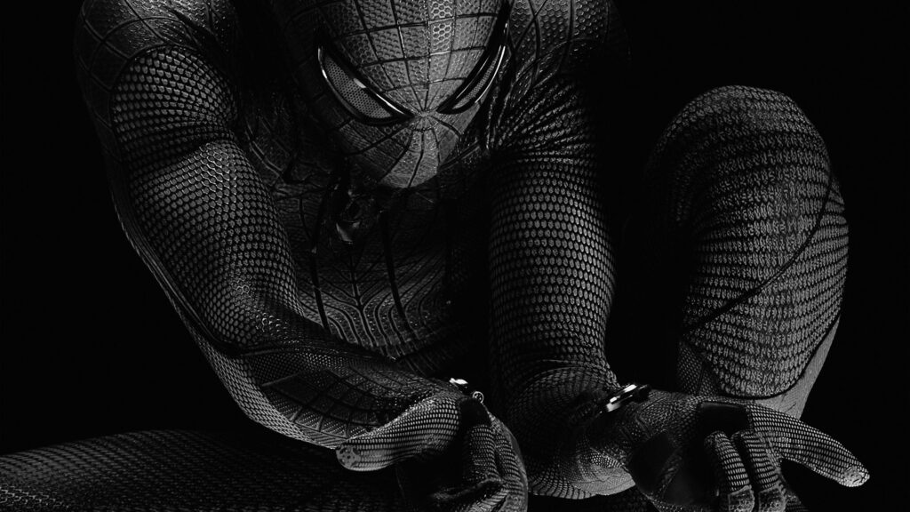 Nightly Web-Slinging: Intense Spider-Man in Black Suit on Laptop Background Wallpaper