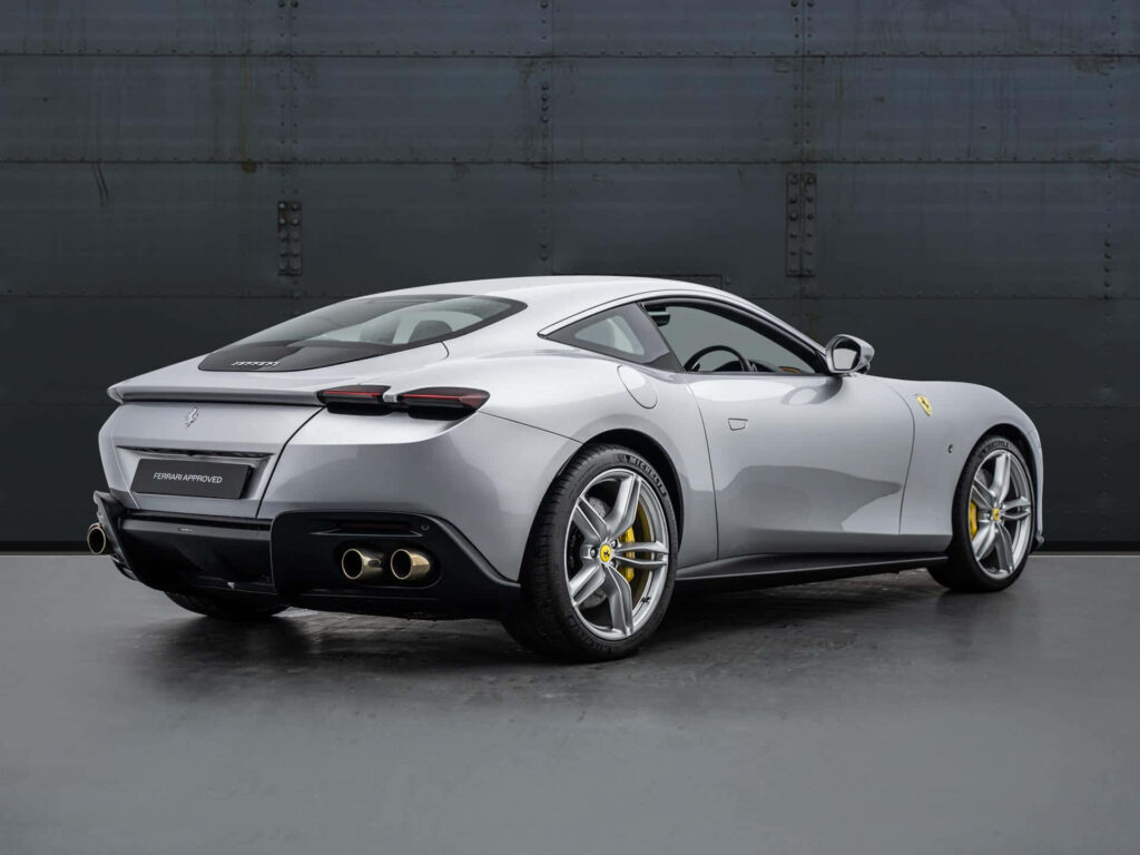Cruising in Style: Captivating the Essence of the Luxurious Ferrari Roma on a Breathtaking Coastal Drive Wallpaper