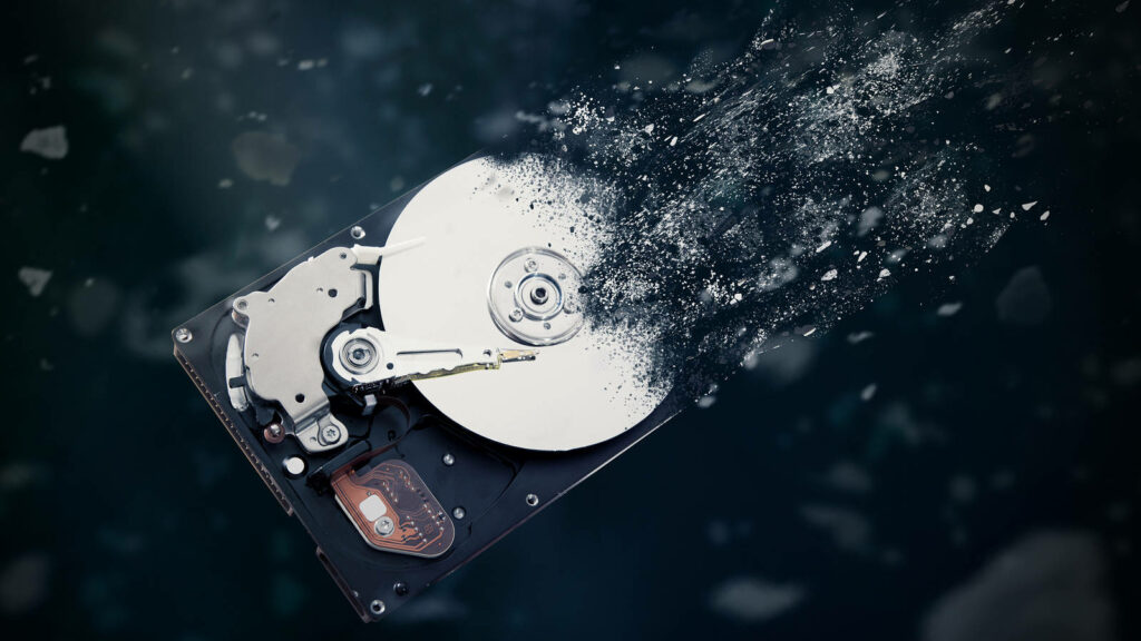 Fading Technology: A Surreal Depiction of Disintegrating Hard Drive Components against a Noir Background Wallpaper