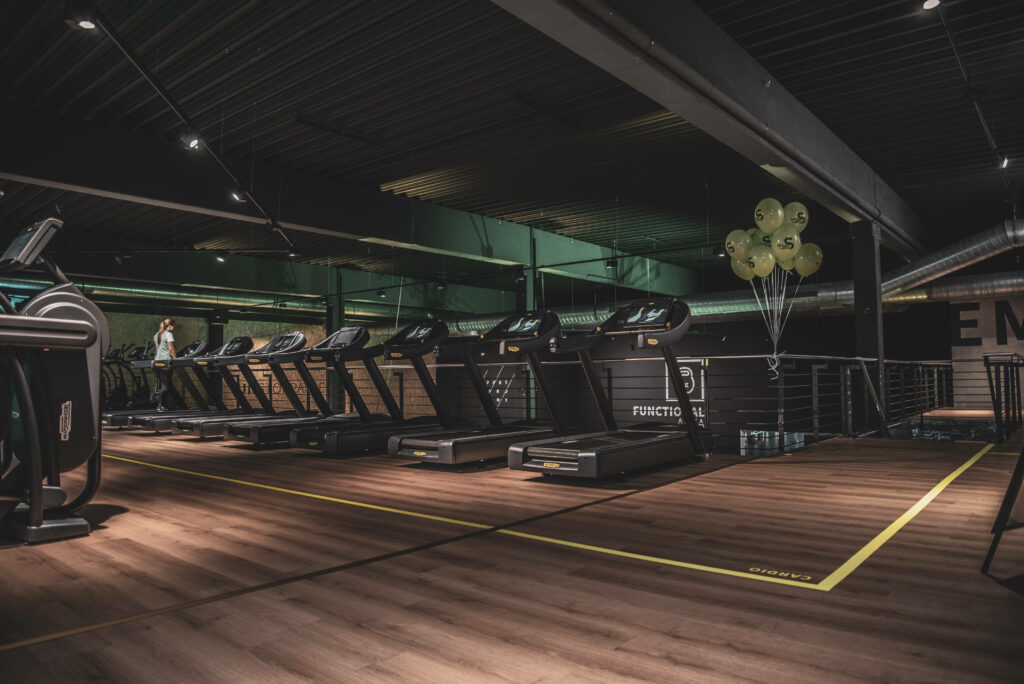 Luxe Loft Gym Vibes: Treadmills and Wood Panel Floors in High Ceiling Space Wallpaper
