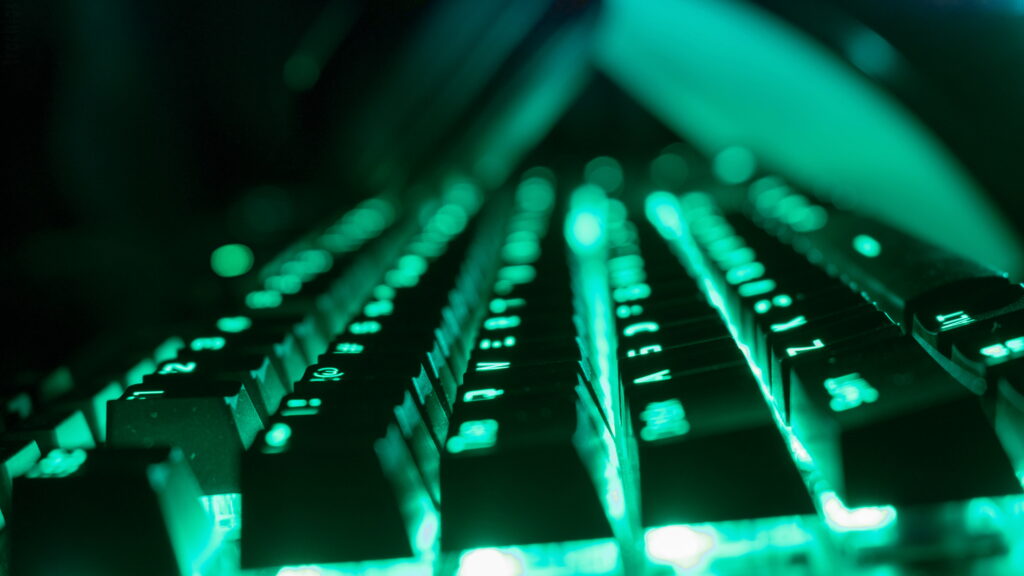 Close-up of sleek mechanical keyboard with vibrant neon green backlight for gaming setup Wallpaper