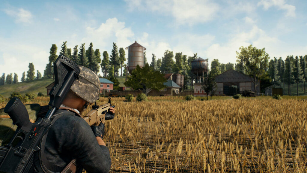 PUBG soldier aiming rifle in sunlit wheat field with water towers cinematic battle royale wallpaper