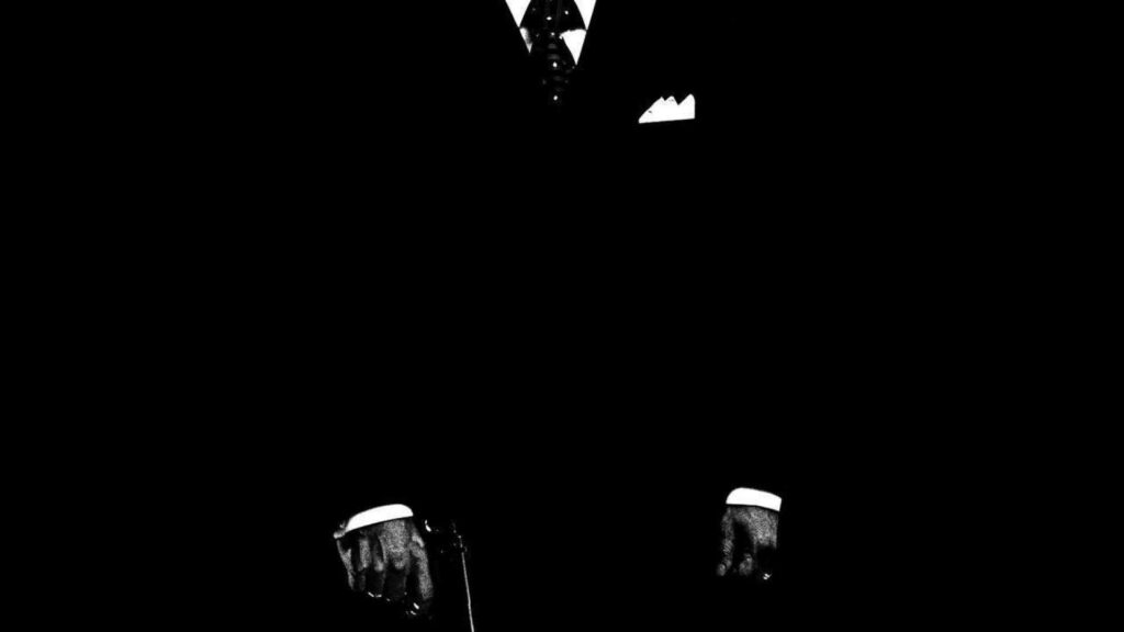 Underworld Elegance: An Italian Mobster's Enigmatic Stroll Amid Shadows Wallpaper