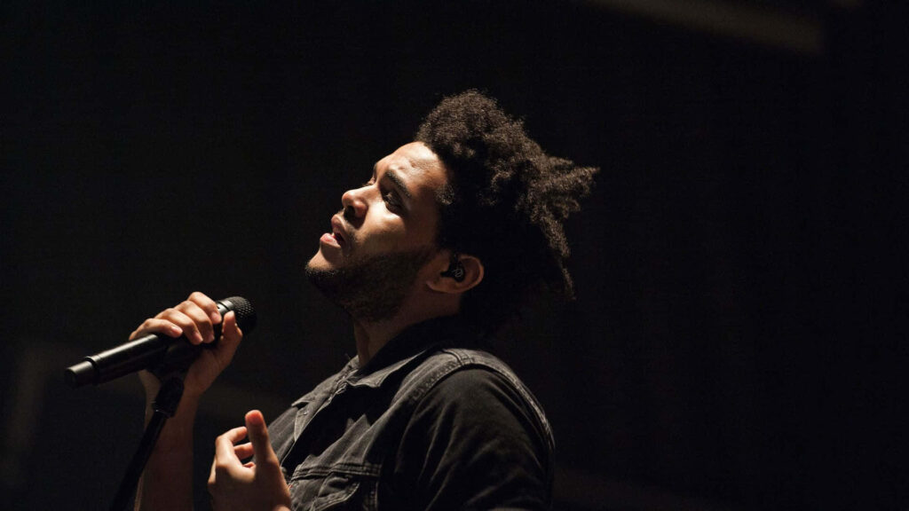 The Weeknd Wallpaper: Passionate Performance with Dynamic Background