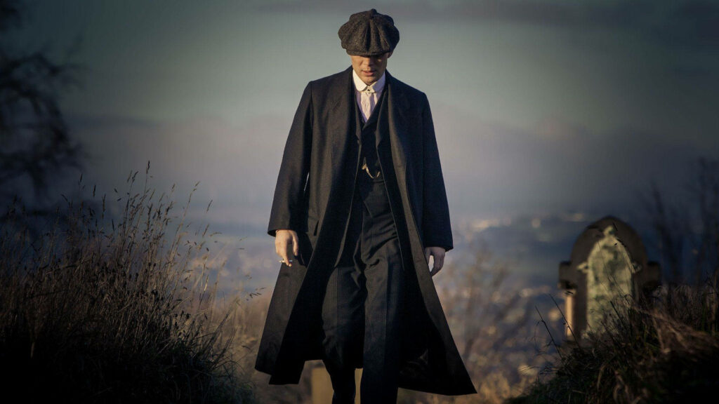 The Resolute Observer: Thomas Shelby Amidst Mountain Vistas - A Captivating Peaky Blinders Vignette Wallpaper