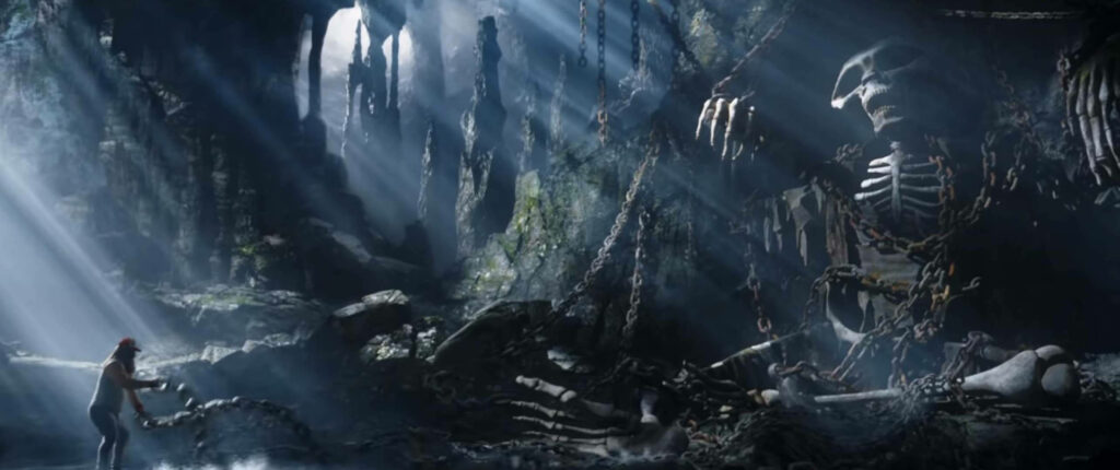 Dramatic Thor Love and Thunder wallpaper of massive chained skeleton in shadowy cave with light rays