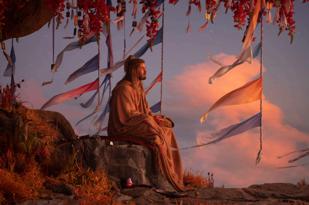 Thor meditating peacefully under a ribbon-draped tree at sunset serene Thor Love and Thunder wallpaper