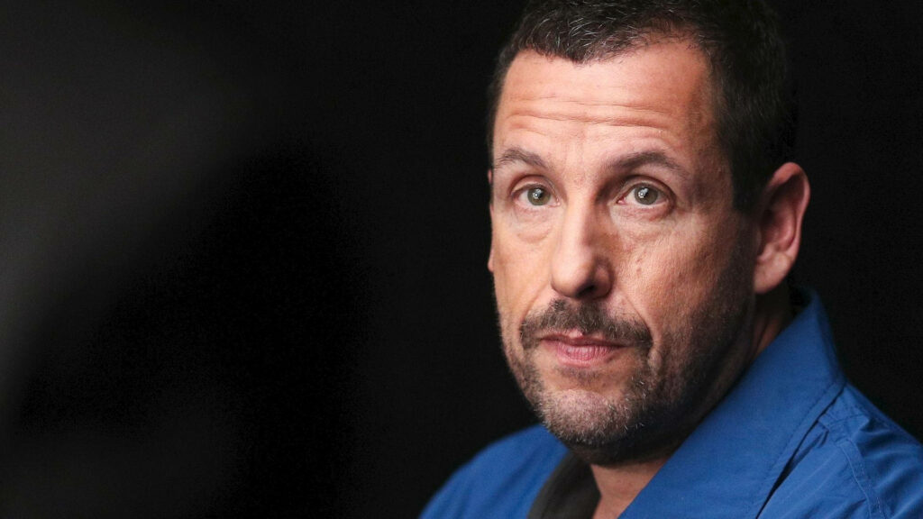 Adam Sandler thoughtful and introspective portrait in dark moody wallpaper background