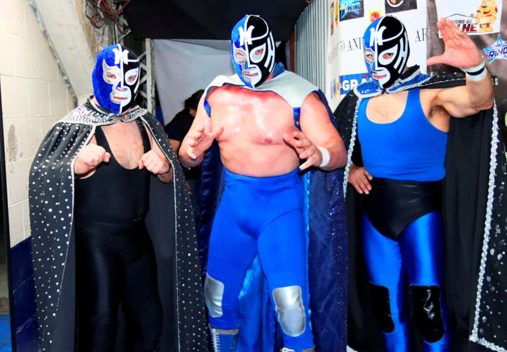 Three masked wrestlers in blue silver costumes pose backstage showing strength and unity wallpaper