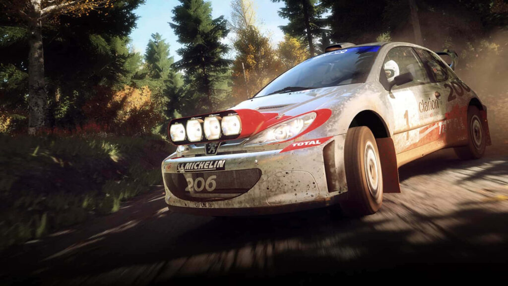 High-Octane Dirt Rally Racing: Number 206 Rally Car Power Sliding Through Woodland Course with Michelin and Total Sponsor Logos Wallpaper