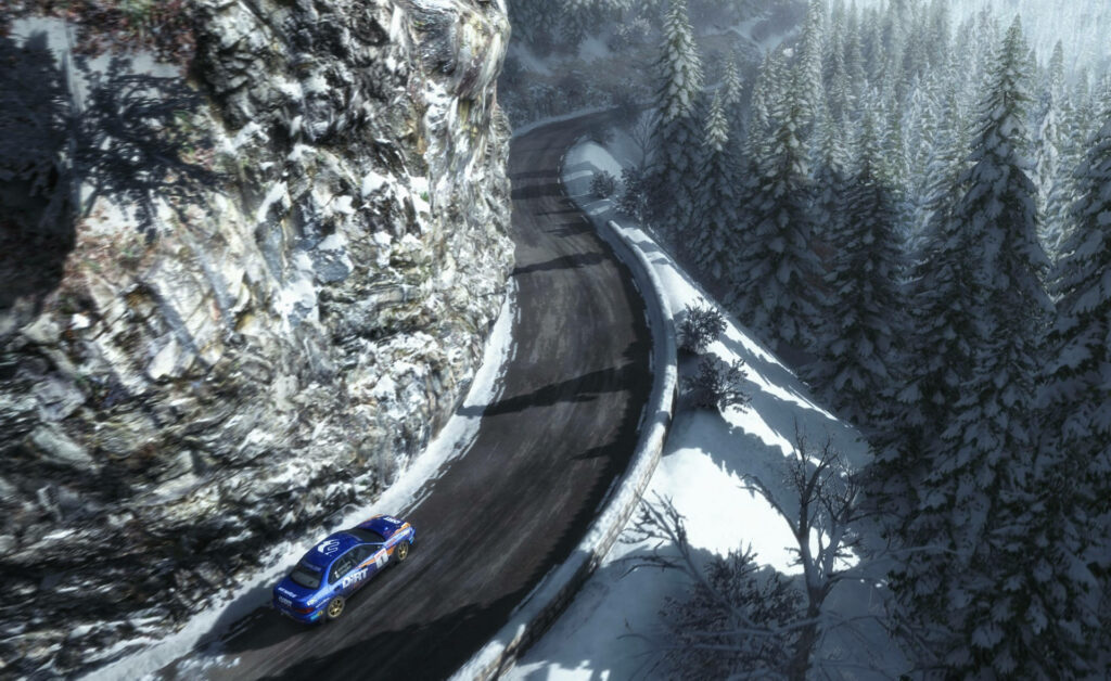 Thrill of the Mountains: A Striking Aerial Shot Capturing a Blue Speedster from 'Dirt Rally' Tackling the Majestic Landscape Wallpaper