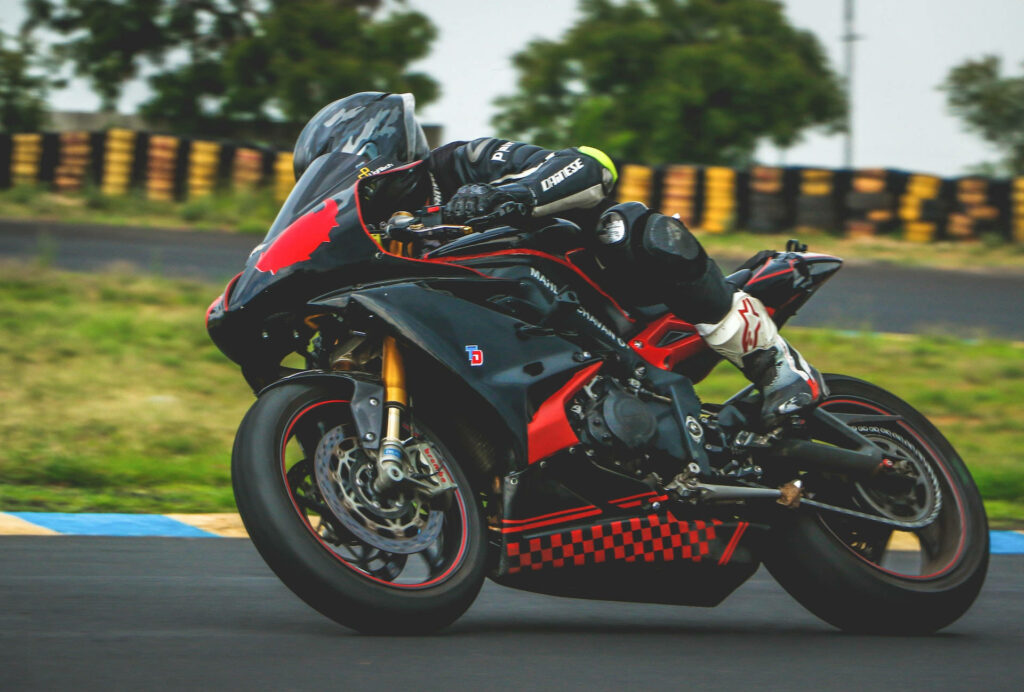 Thrilling Bike Rider Wallpaper: High-Speed Race Track Action
