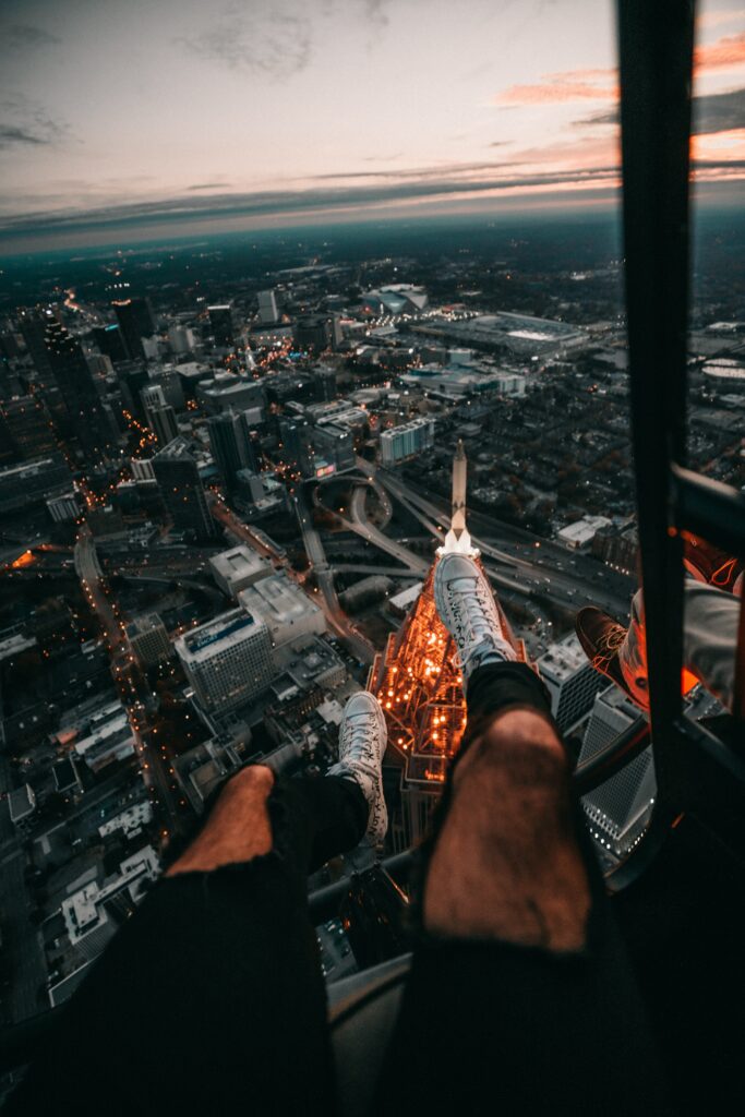 Thrilling Aerial City Dusk Wallpaper with Adventurous Legs