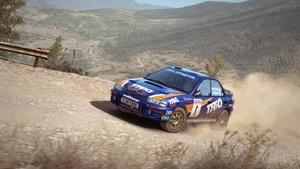 Blue rally car speeding through dusty terrain in dirt rally racing game wallpaper