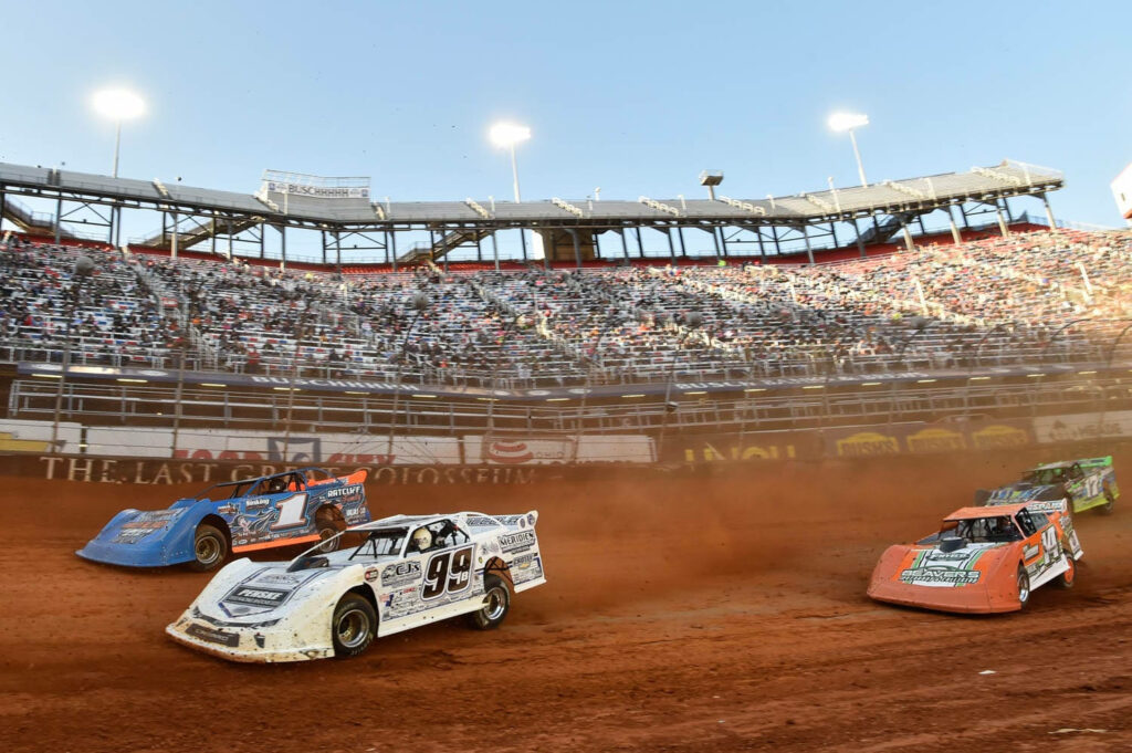 Thrilling dirt track stock car race with red dust clouds and bright stadium lights background Wallpaper