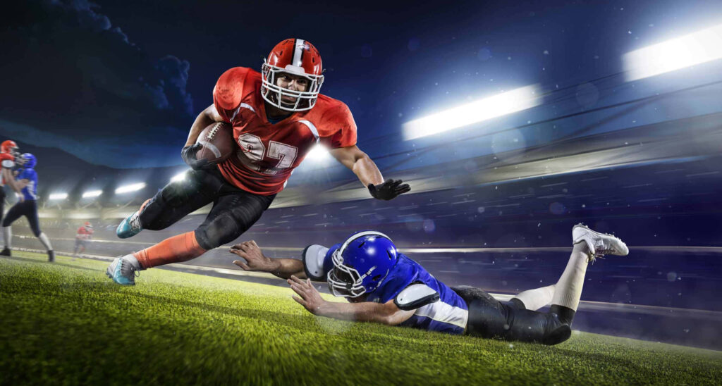 Thrilling Football Action Wallpaper: Player Dodging Tackle in Red Jersey
