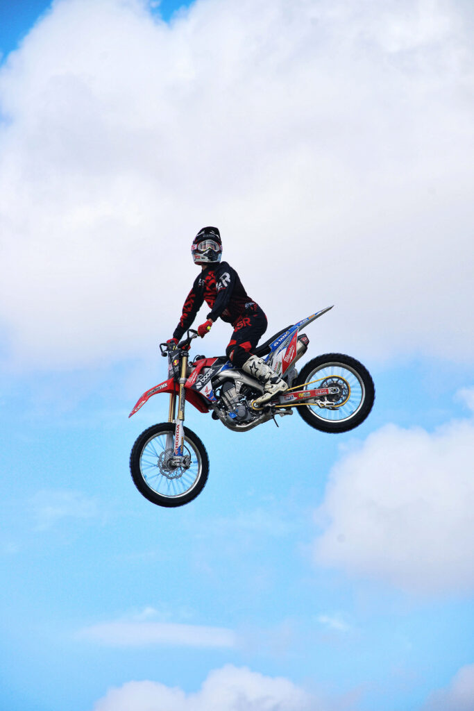 Thrilling Honda Dirt Bike Rider Wallpaper: Adventure in Clear Skies