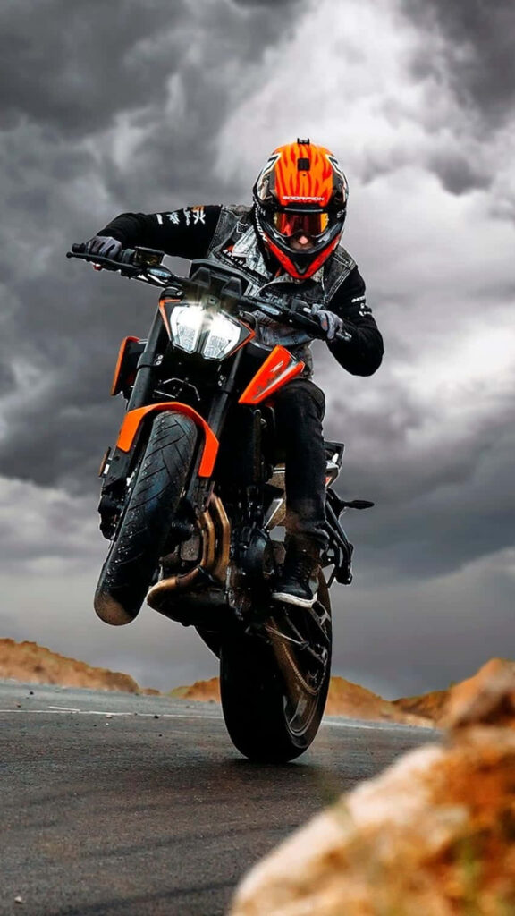 Dynamic KTM Bike Wallpaper: Mid-Wheelie Action & Dramatic Clouds