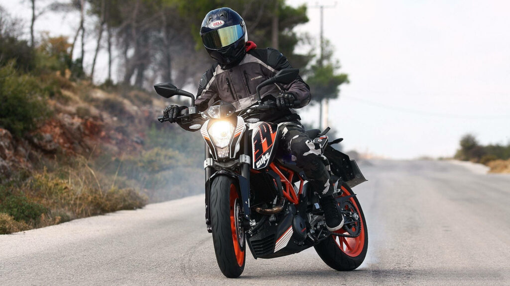 Thrilling KTM Duke 390 Rider Wallpaper: Iconic Orange Action Shot