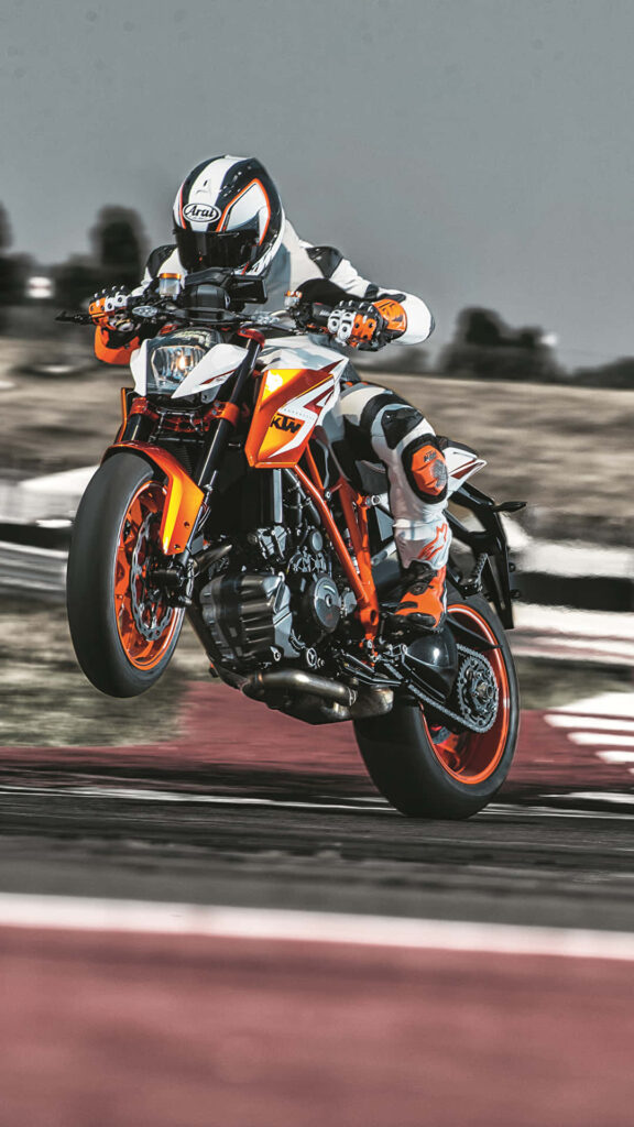 Vibrant KTM Motorcycle Wallpaper: Action-Packed Wheelie Scene