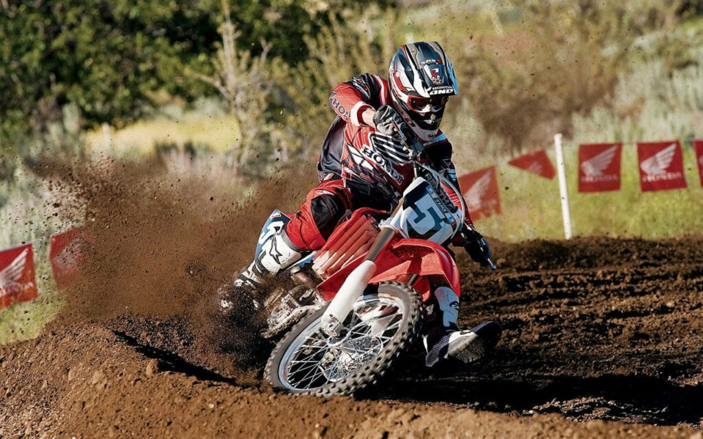 Exciting Motocross Wallpaper: Honda Rider in Action on Dirt Track