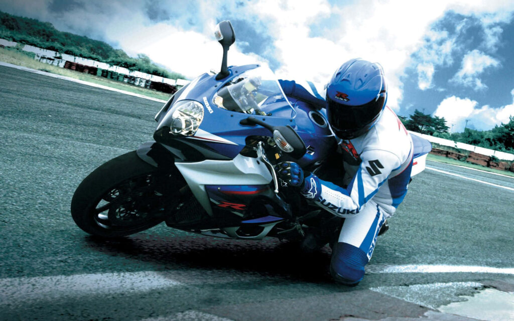 Thrilling Motorcycle Action Wallpaper on a Racetrack
