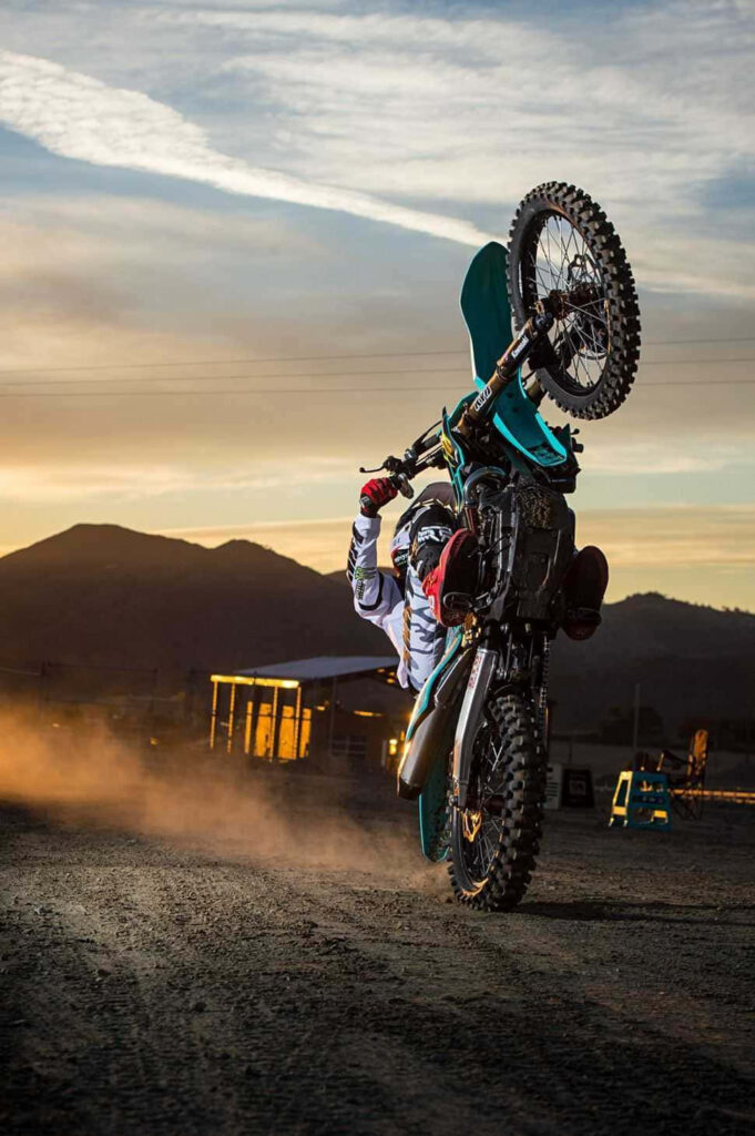 Stunning Motorcycle Adventure Wallpaper: Bold Sunset Wheelie Scene