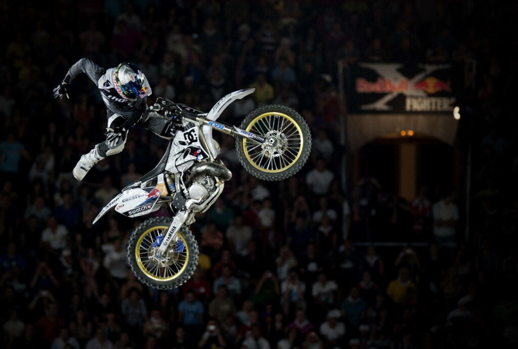 Dynamic Motorcycle Stunt Wallpaper: Thrilling Mid-Air Action & Excitement