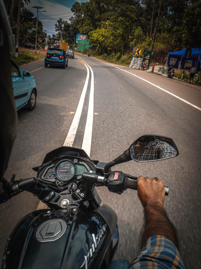 Thrilling NS 200 Motorcycle Ride Wallpaper Amid Lush Greenery