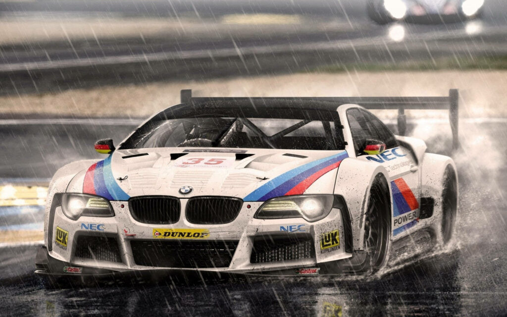 Drenched in Speed: Captivating BMW Auto Racing Car Surges through Rainy Racetrack Wallpaper