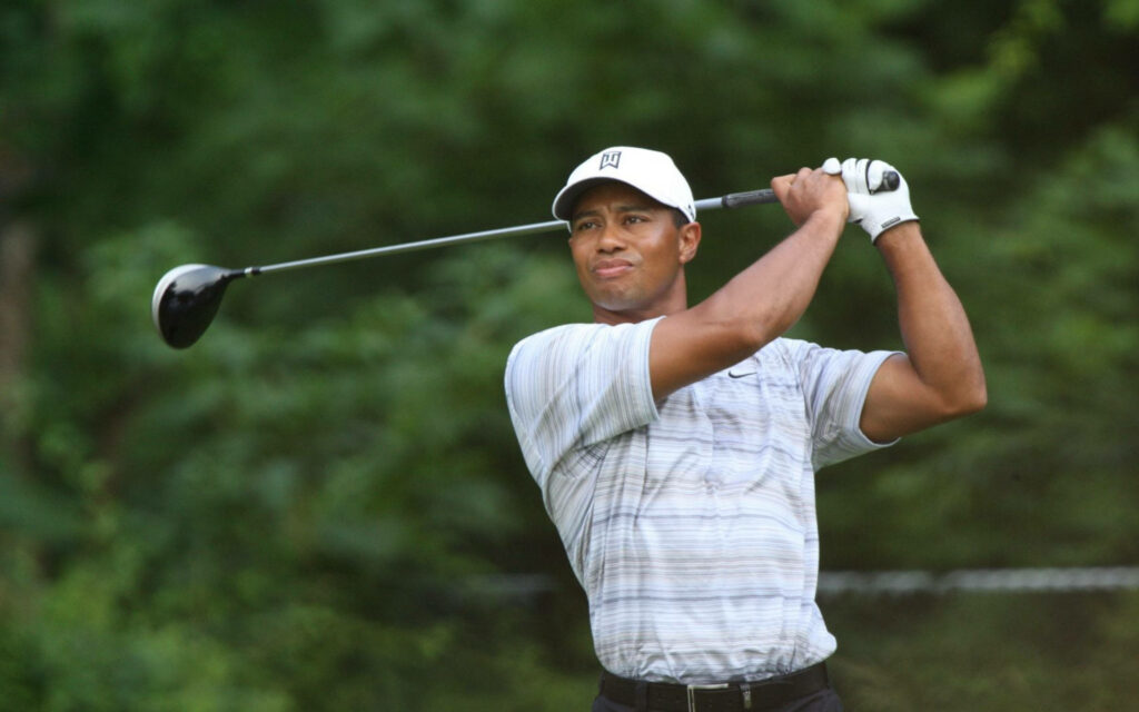 Tiger Woods mid swing at 2007 Memorial golf tournament with lush green background wallpaper