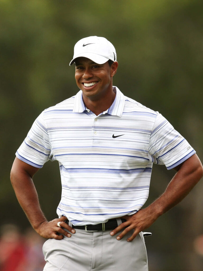 Tiger Woods smiling confidently on golf course iPhone wallpaper showcasing iconic athletic presence