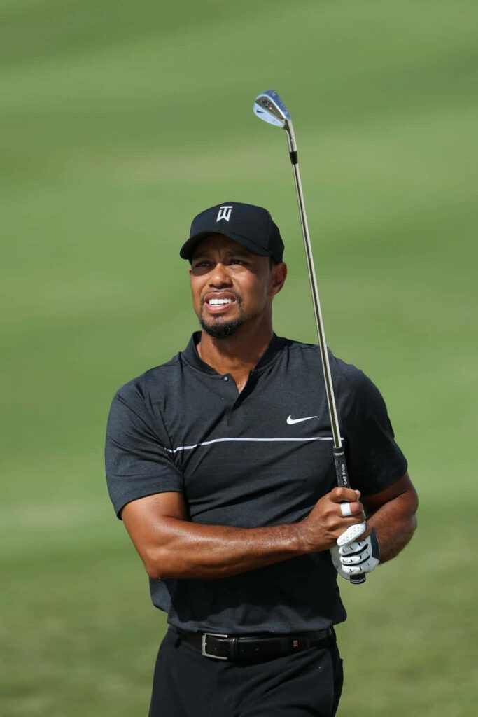 Tiger Woods smiling confidently on golf course iPhone wallpaper capturing iconic presence