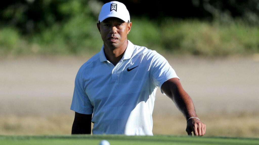 Tiger Woods focused on golf course wearing white shirt and cap during 2018 Genesis tournament Wallpaper