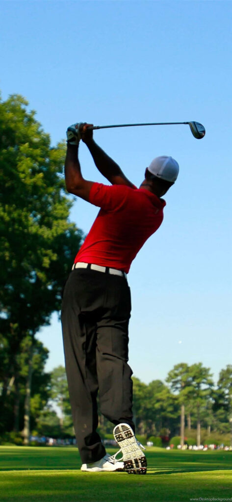 Tiger Woods mid-swing on vibrant golf course wearing red shirt and white cap iPhone wallpaper