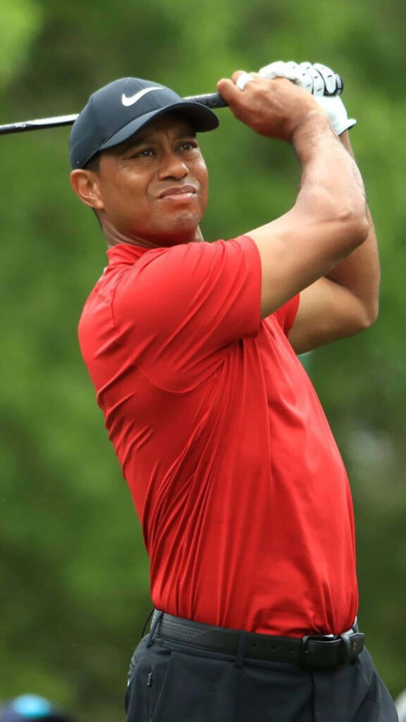 Tiger Woods mid swing in red shirt and black cap golf course dynamic iPhone wallpaper background