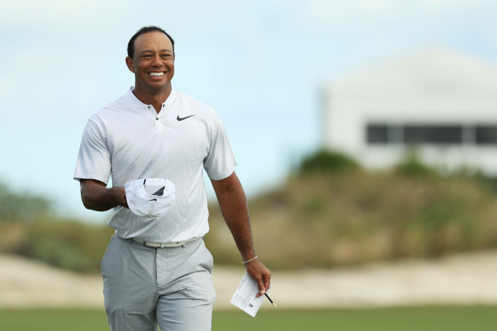 Tiger Woods smiling on golf course 2017 Hero World Challenge wearing white Nike shirt holding scorecard Wallpaper