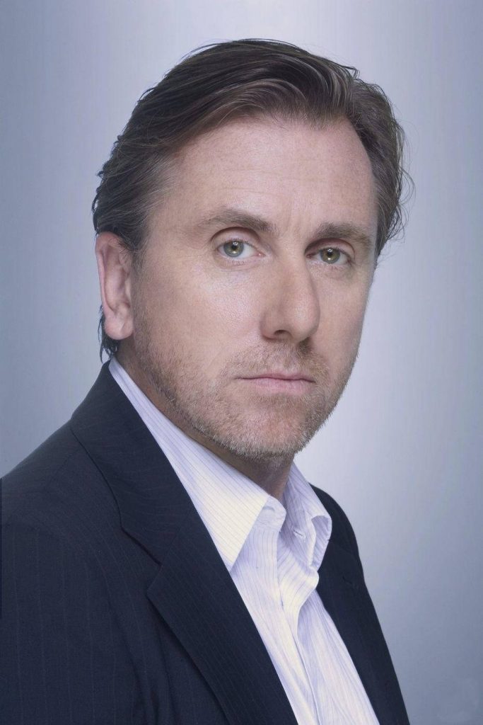Tim Roth portrait wallpaper in dark formal suit with intense expression on neutral background