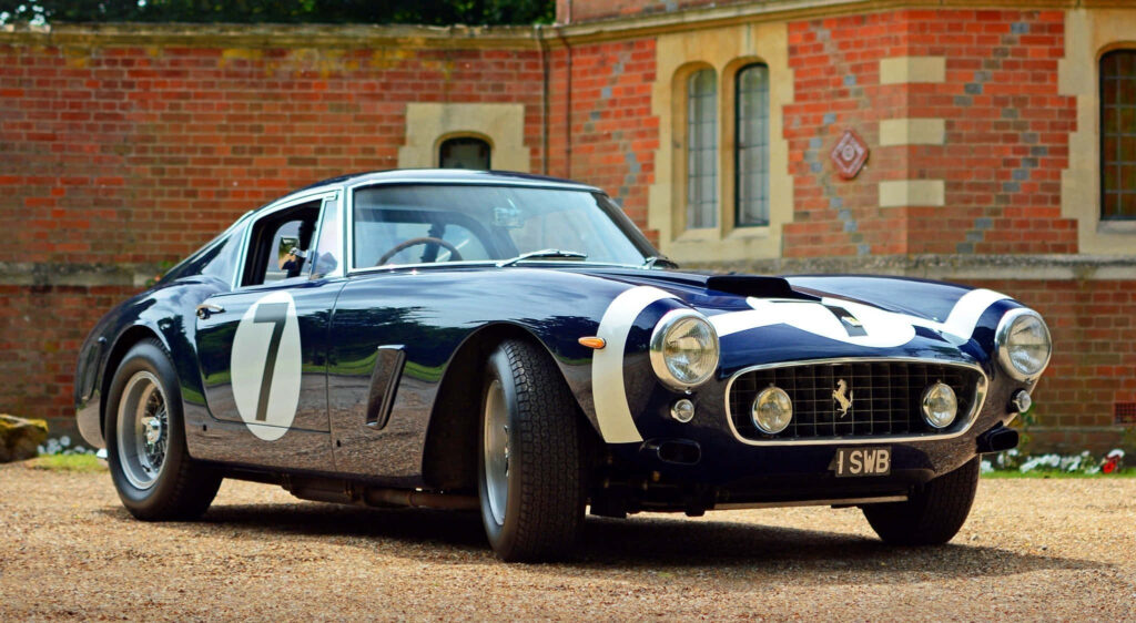 Timeless Elegance on a Coastal Drive: A Vibrant Classic Ferrari Against a Breathtaking Scenic Backdrop Wallpaper