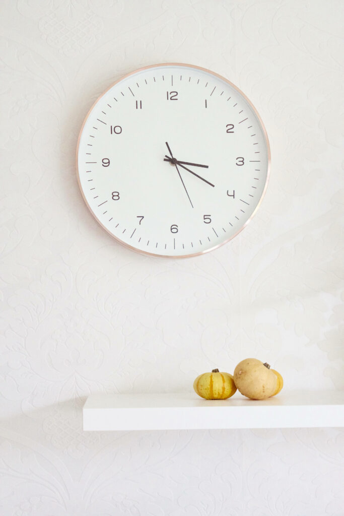 Elegant Timepiece Adorning a Minimalist Concrete Wall Wallpaper