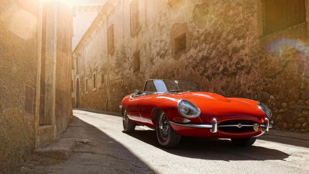 Timeless Jaguar E-Type Wallpaper: Classic Red Convertible Scene