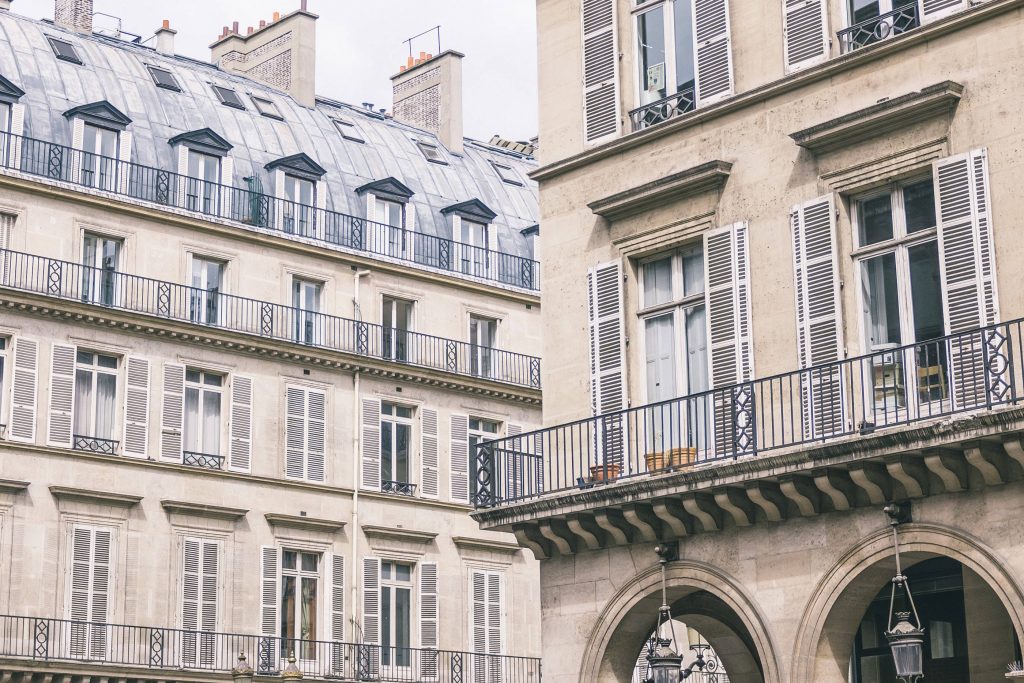 Classic Parisian Haussmann architecture with creamy stone facades and wrought iron balconies Wallpaper