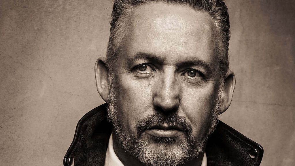Sepia portrait of middle-aged man with salt and pepper beard wearing leather jacket close-up Wallpaper