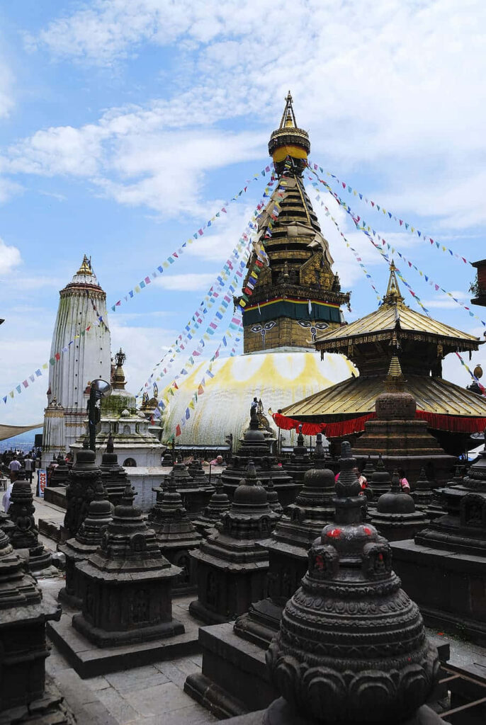 Boudhanath Stupa with vibrant prayer flags blue sky ancient Buddhist architecture wallpaper