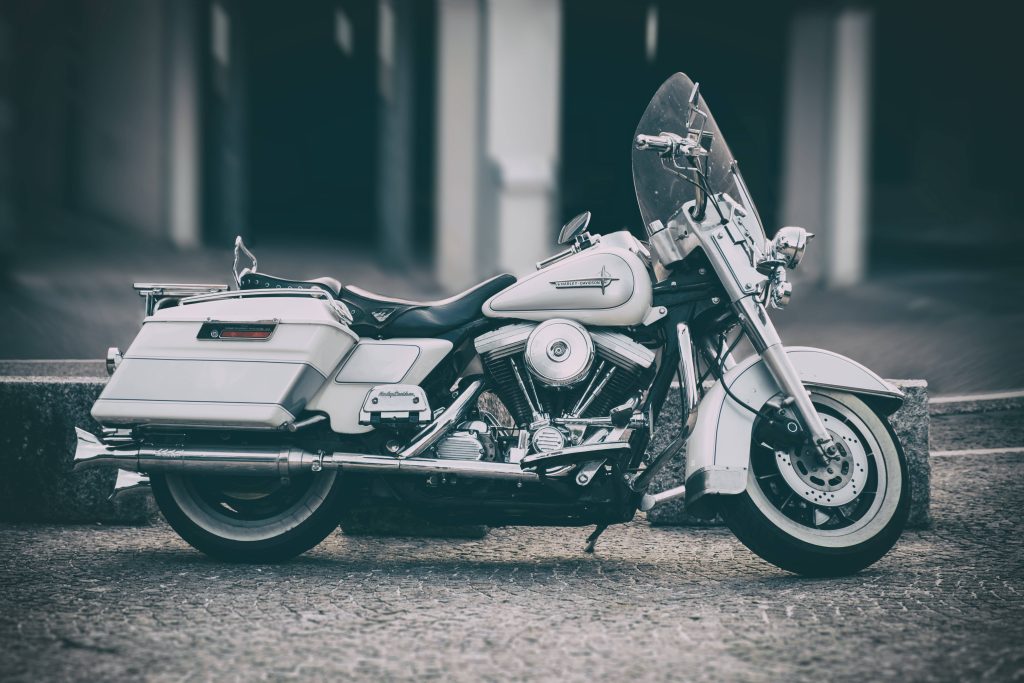 White Harley-Davidson cruiser with chrome accents and saddlebags on cobblestone path wallpaper